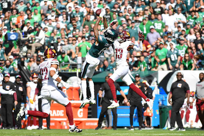 Philadelphia Eagles receiver DeVonta Smith (6) makes a leaping catch over Washington Commanders cornerback Emmanuel Forbes (13).